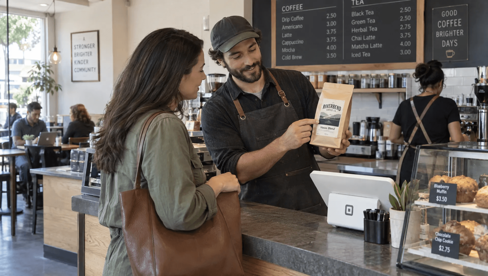 A business owner presents a newly packaged product to a customer at a café counter, capturing it in everyday use.